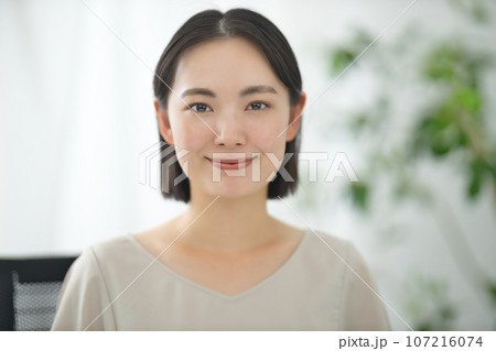 カメラ目線で話す笑顔の若いビジネスウーマン  107216074