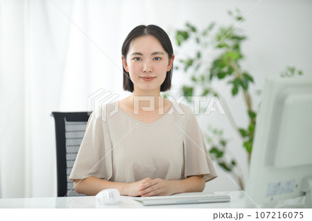 カメラ目線で話す真顔の若いビジネスウーマン カメラ目線で話す真顔の若いビジネスウーマン 107216075