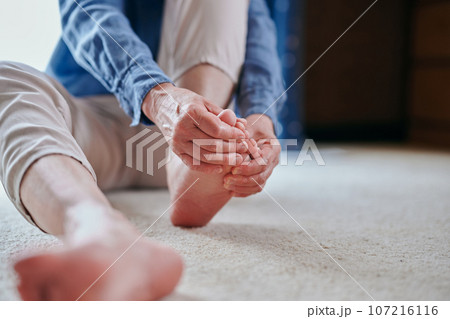 足をマッサージする冷え性のシニア女性 107216116