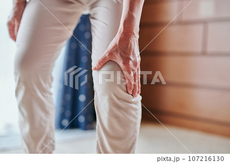 膝が痛くて手で押さえるシニア女性 膝が痛くて手で押さえるシニア女性 107216130