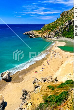 View of sandy beach of Preveli, Crete island, Greece on clear sunny day. Travel destination, river and clear Lybian sea waters, forest, palm trees, gorge, blue sky with clouds. Tourist swim and View of sandy beach of Preveli, Crete island, Greece on clear sunny day. Travel destination, river and clear Lybian sea waters, forest, palm trees, gorge, blue sky with clouds. Tourist swim and 107216172