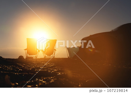 evening tourist camp with car. morning sun rays in the background, outdoor recreation area evening tourist camp with car. morning sun rays in the background, outdoor recreation area 107219814