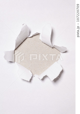 Paper hole with torn sides in paper texture with copy space 107220709