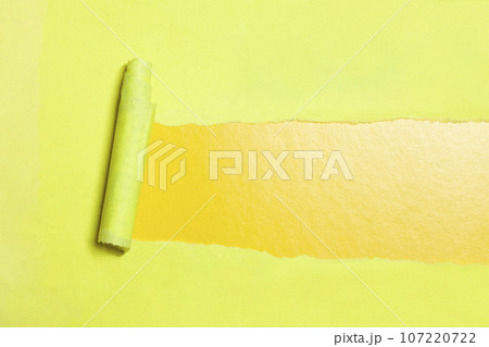 Torn paper with opening showing yellow background. 107220722