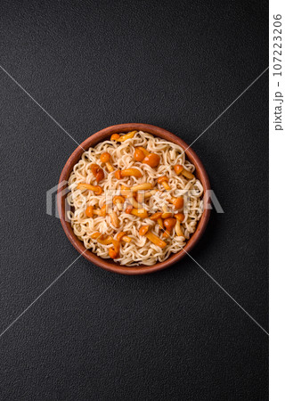 Delicious Asian cuisine dish with rice noodles, peppers, mushrooms and spices Delicious Asian cuisine dish with rice noodles, peppers, mushrooms and spices 107223206