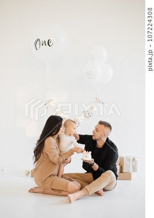 Caring parents greeting daughter with birthday cake indoors Caring parents greeting daughter with birthday cake indoors 107224308