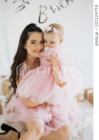 Mother with daughter posing in studio with birthday decor Mother with daughter posing in studio with birthday decor 107224759