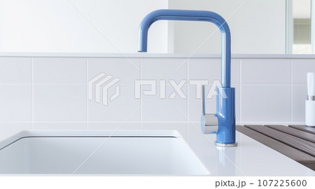 Fragment of a modern luxury white kitchen. Countertop with built-in sink, blue faucet. White tile backsplash. Close-up. Contemporary interior design. 3D rendering. 107225600