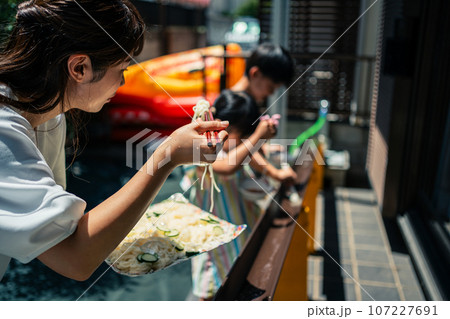お庭で雨どい流しそうめんをする家族 お庭で雨どい流しそうめんをする家族 107227691