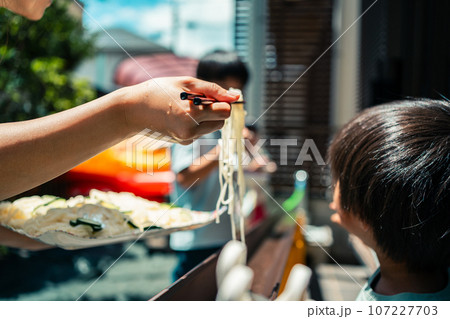 お庭で雨どい流しそうめんをする家族 お庭で雨どい流しそうめんをする家族 107227703