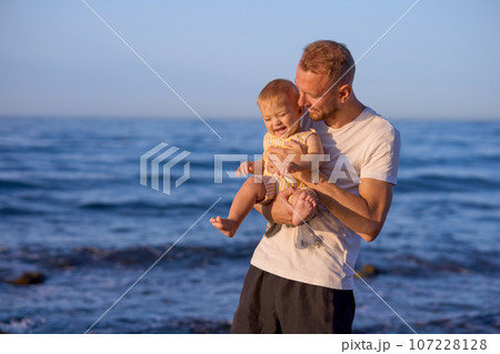 Father and son on the seashore at sunset. Happy family. Father and son on the seashore at sunset. Happy family. 107228128