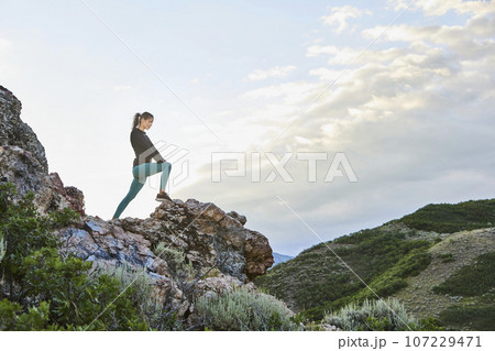 Mid adult woman hiking in mountains Mid adult woman hiking in mountains 107229471
