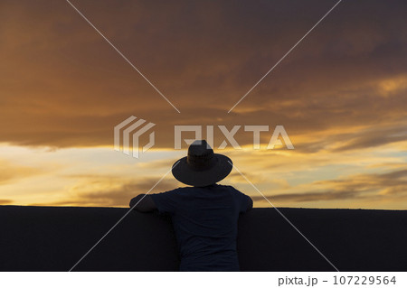 USA, New Mexico, Santa Fe, Silhouette of man in hat looking at sunset USA, New Mexico, Santa Fe, Silhouette of man in hat looking at sunset 107229564