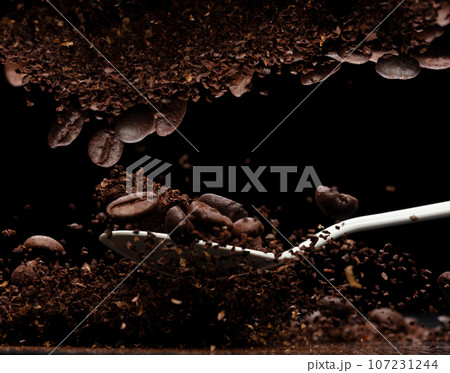 Coffee powder fly explosion, Coffee crushed ground float pouring, wave like smoke smell. Coffee ground powder splash throwing in mid Air. Black background Isolated series two of images Coffee powder fly explosion, Coffee crushed ground float pouring, wave like smoke smell. Coffee ground powder splash throwing in mid Air. Black background Isolated series two of images 107231244