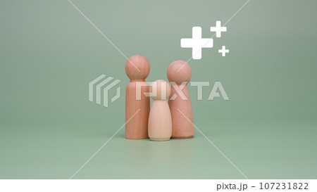 The concept of health insurance and medical welfare. Family of model wooden doll and plus sign on a green background. Health insurance and access to health care. health care planning The concept of health insurance and medical welfare. Family of model wooden doll and plus sign on a green background. Health insurance and access to health care. health care planning 107231822