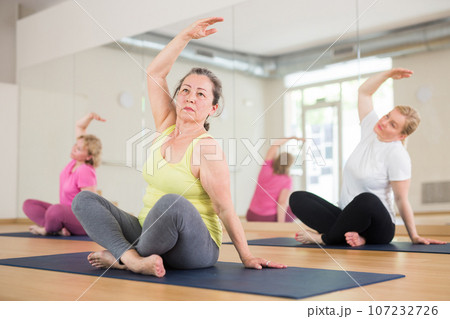 Aged women are sitting in a lotus pose 107232726