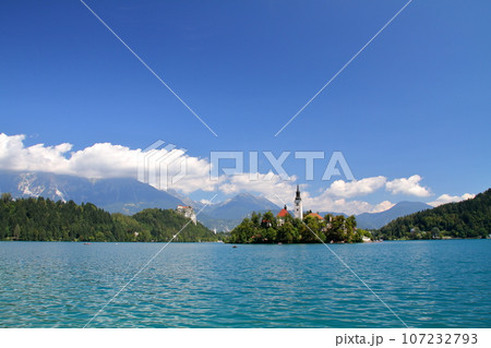 南欧スロヴェニアのブレッド湖　湖面に浮かぶブレッド島の聖母被昇天教会とブレッド城とユリアンアルプス 107232793
