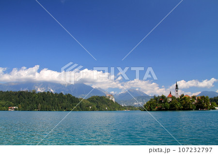 南欧スロヴェニアのブレッド湖　湖面に浮かぶブレッド島の聖母被昇天教会とブレッド城とユリアンアルプス 107232797