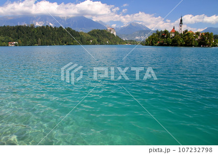 南欧スロヴェニアのブレッド湖　湖面に浮かぶブレッド島の聖母被昇天教会とブレッド城とユリアンアルプス 107232798