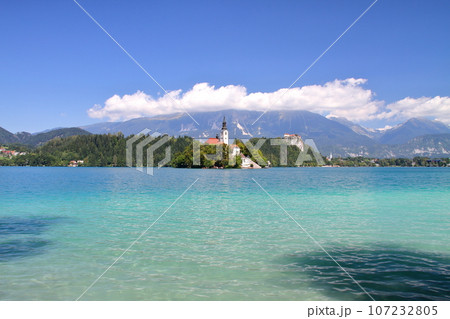 南欧スロヴェニアのブレッド湖　湖面に浮かぶブレッド島の聖母被昇天教会とブレッド城とユリアンアルプス 107232805