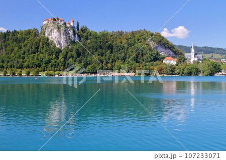 南欧スロヴェニアのブレッド湖　ターコイズブルーの湖岸の断崖の上に建つブレッド城 107233071