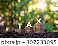 The word tax on a pile of coins on the floor Concepts for planning tax reductions, expenses, accounting, VAT, income tax, and tax calculations. 107233095