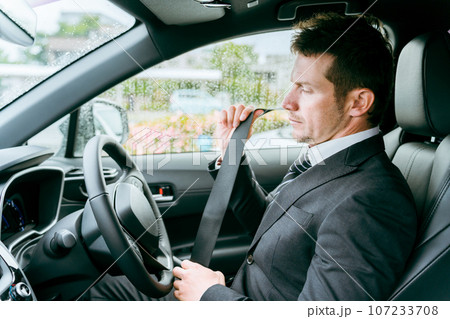 車でシートベルトをしめる外国人ビジネスマン・ドライバー・運転手・出張・外出・カーシェアリング 車でシートベルトをしめる外国人ビジネスマン・ドライバー・運転手・出張・外出・カーシェアリング 107233708