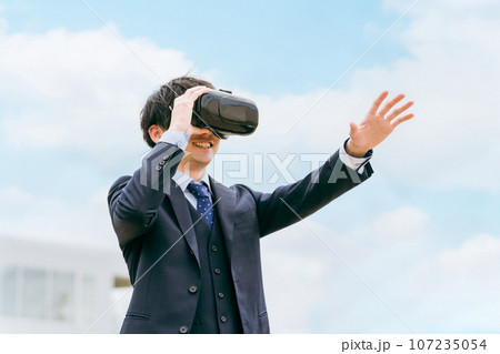 VRゴーグルをつけてバーチャルリアリティ・メタバースを体験するビジネスマン・研修 VRゴーグルをつけてバーチャルリアリティ・メタバースを体験するビジネスマン・研修 107235054