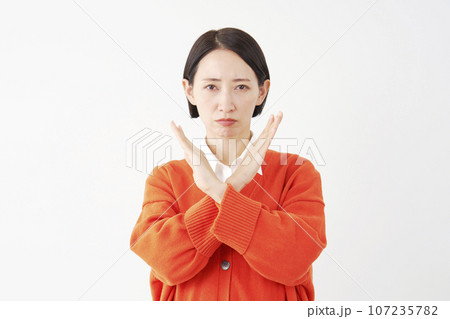 腕でばつ印のジェスチャーをする女性 白背景 腕でばつ印のジェスチャーをする女性 白背景 107235782