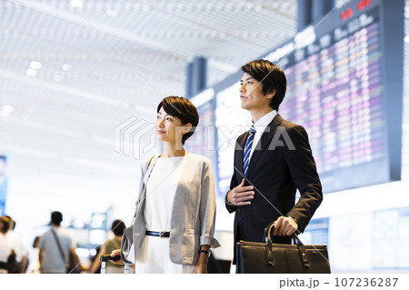 空港から出張に出かける男女の若いビジネスマン 107236287