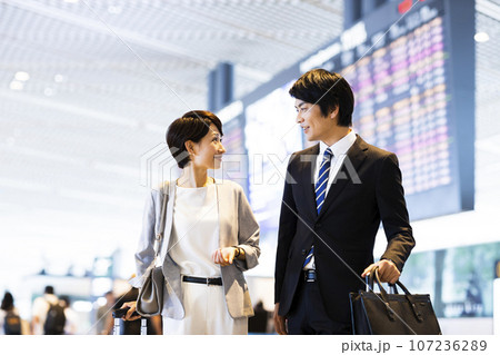 空港から出張に出かける男女の若いビジネスマン 空港から出張に出かける男女の若いビジネスマン 107236289