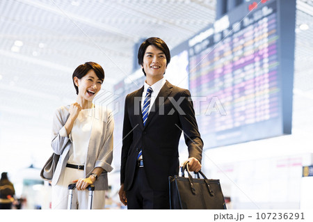空港から出張に出かける男女の若いビジネスマン 107236291