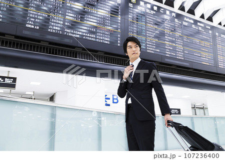 空港から出張をする若いビジネスマン 空港から出張をする若いビジネスマン 107236400