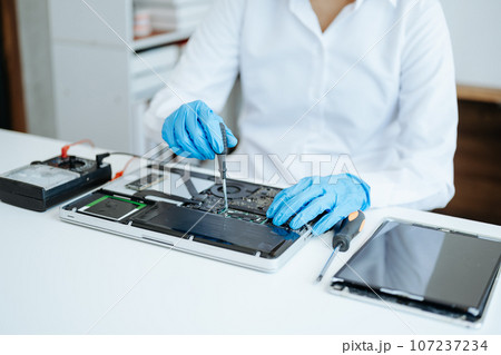 Electronics technician, electronic engineering electronic repair,electronics measuring and testing, repair and maintenance concepts.uses a voltage meter to check and upgrade 107237234