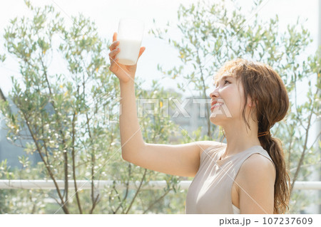 トレーニング後にプロテインを飲むスポーツウーマン・健康的な女性（牛乳・豆乳・スムージー・シェイク） 107237609