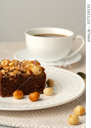 Brownie cake with nuts topping on plate close up 107238230