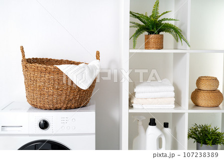 Laundry room with washing machine and basket with laundry Laundry room with washing machine and basket with laundry 107238389