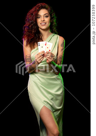 Happy young brunette demonstrating set of winning pair of aces Happy young brunette demonstrating set of winning pair of aces 107238399