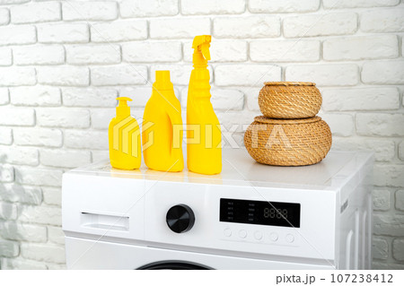 Detergent bottle on washing machine in a laundry room Detergent bottle on washing machine in a laundry room 107238412