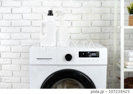 Detergent bottle on washing machine in a laundry room 107238425