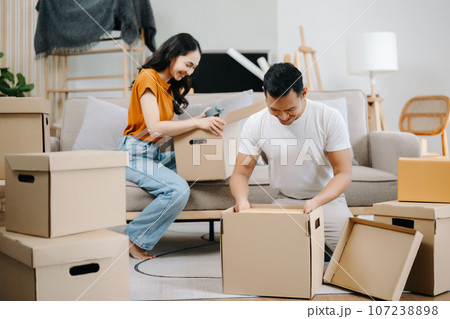 Happy asian young attractive couple man and woman with big boxes moving into a new house, new apartment for couple the new home, Moving house. Happy asian young attractive couple man and woman with big boxes moving into a new house, new apartment for couple the new home, Moving house. 107238898
