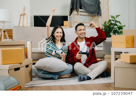 Asian young attractive couple man and woman use tablet and smartphone online shopping furniture decorate house with carton package move in new house. . Asian young attractive couple man and woman use tablet and smartphone online shopping furniture decorate house with carton package move in new house. . 107239047