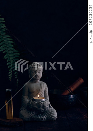 stone statue of buddha with a candle stone statue of buddha with a candle 107239254