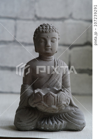 a small stone statue of Buddha a small stone statue of Buddha 107239291