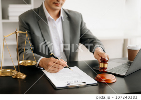 justice and law concept.Male judge in a courtroom on wooden table and Counselor or Male lawyer working in office. . justice and law concept.Male judge in a courtroom on wooden table and Counselor or Male lawyer working in office. . 107240383
