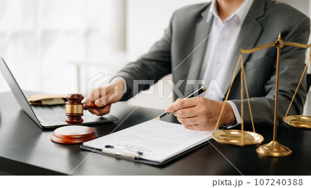 justice and law concept.Male judge in a courtroom on wooden table and Counselor or Male lawyer working in office. . justice and law concept.Male judge in a courtroom on wooden table and Counselor or Male lawyer working in office. . 107240388