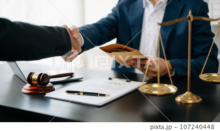 Man lawyer hand and women client shaking hand collaborate on working agreements with contract documents at the modern office. Man lawyer hand and women client shaking hand collaborate on working agreements with contract documents at the modern office. 107240448