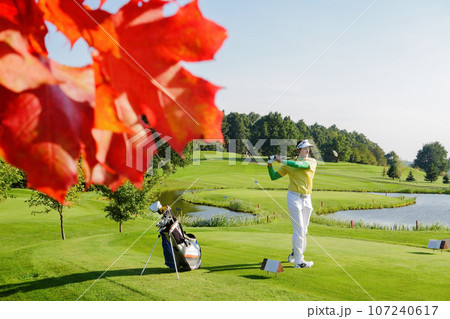 Man playing golf during colorful autumn 107240617