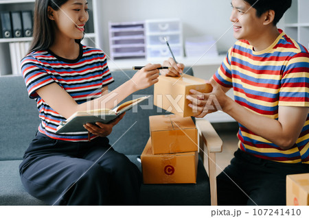 Starting small businesses SME owners, two check online orders Selling products working with boxs freelance work on sofa at home using tablet and laptop marketing, packaging, concept. Starting small businesses SME owners, two check online orders Selling products working with boxs freelance work on sofa at home using tablet and laptop marketing, packaging, concept. 107241410