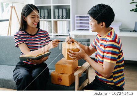 Starting small businesses SME owners, two check online orders Selling products working with boxs freelance work on sofa at home using tablet and laptop marketing, packaging, concept. Starting small businesses SME owners, two check online orders Selling products working with boxs freelance work on sofa at home using tablet and laptop marketing, packaging, concept. 107241412
